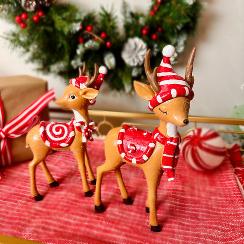 2 reindeer wearing red and white hats, scarves and saddle blankets.  They tie into the Peppermint Park collection by Just Jill.