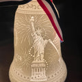 Decorative item with Statue of Liberty design and ribbon on a dark background
